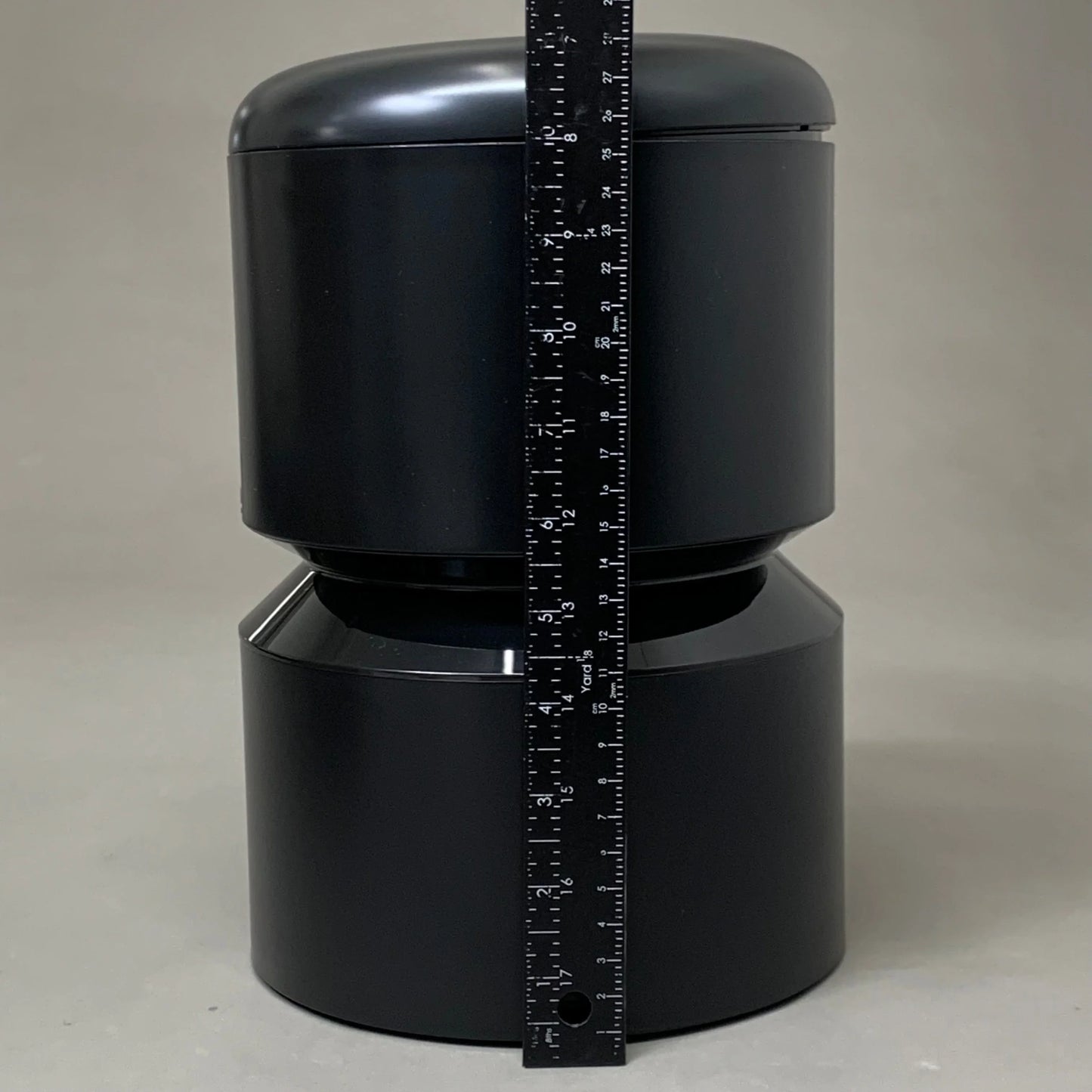 Black automatic cat feeder body with measuring tape vertically