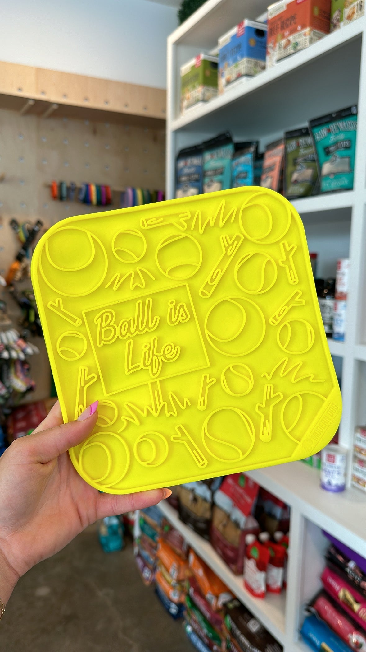 Lime green silicone dog lick mat with raised ball and paw icons and “Ball is Life” text