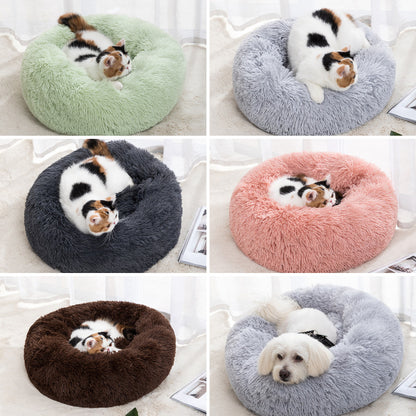 Plush round donut pet bed in light green, with a small cat curled inside.