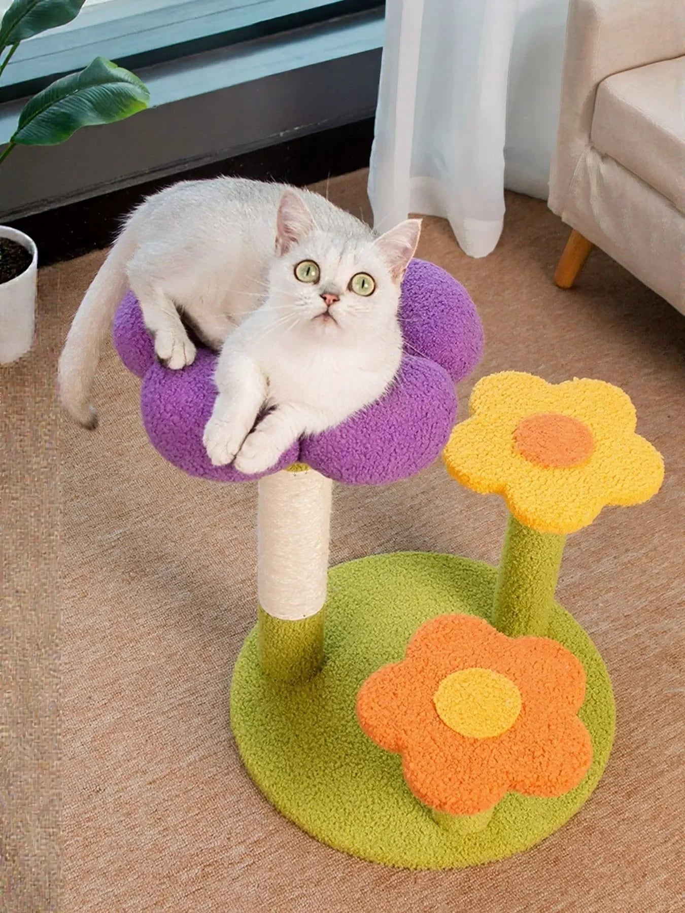 Flower-shaped plush cat tree scratching post with purple petals, green base, and cat