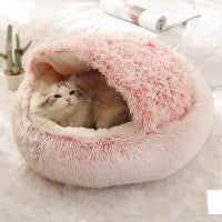 Cozy winter plush pet bed with round cave design, pink fuzzy exterior and open center.