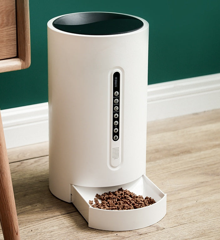 White smart pet feeder with side control panel and front feeding bowl on floor