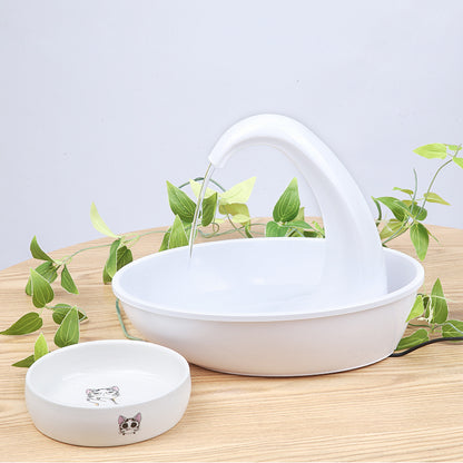 White automatic pet water dispenser bowl with curved spout on wooden surface