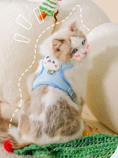 Blue pet harness with mesh panels and plush bear face patch, worn on a cat