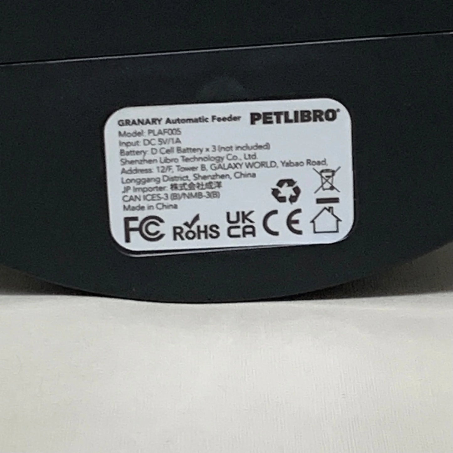 Black automatic cat feeder base label with regulatory and model information