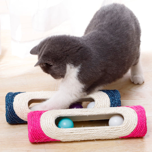 Gray cat pawing a colorful sisal drum cat toy with blue and pink rolling ball lanes