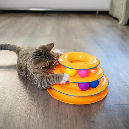 A tabby cat playing with a WTN Essentials 3-tier interactive spinning ball track toy.