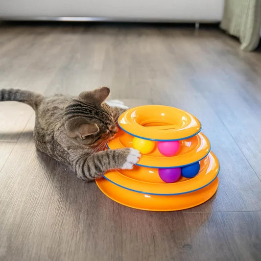 A tabby cat playing with a WTN Essentials 3-tier interactive spinning ball track toy.