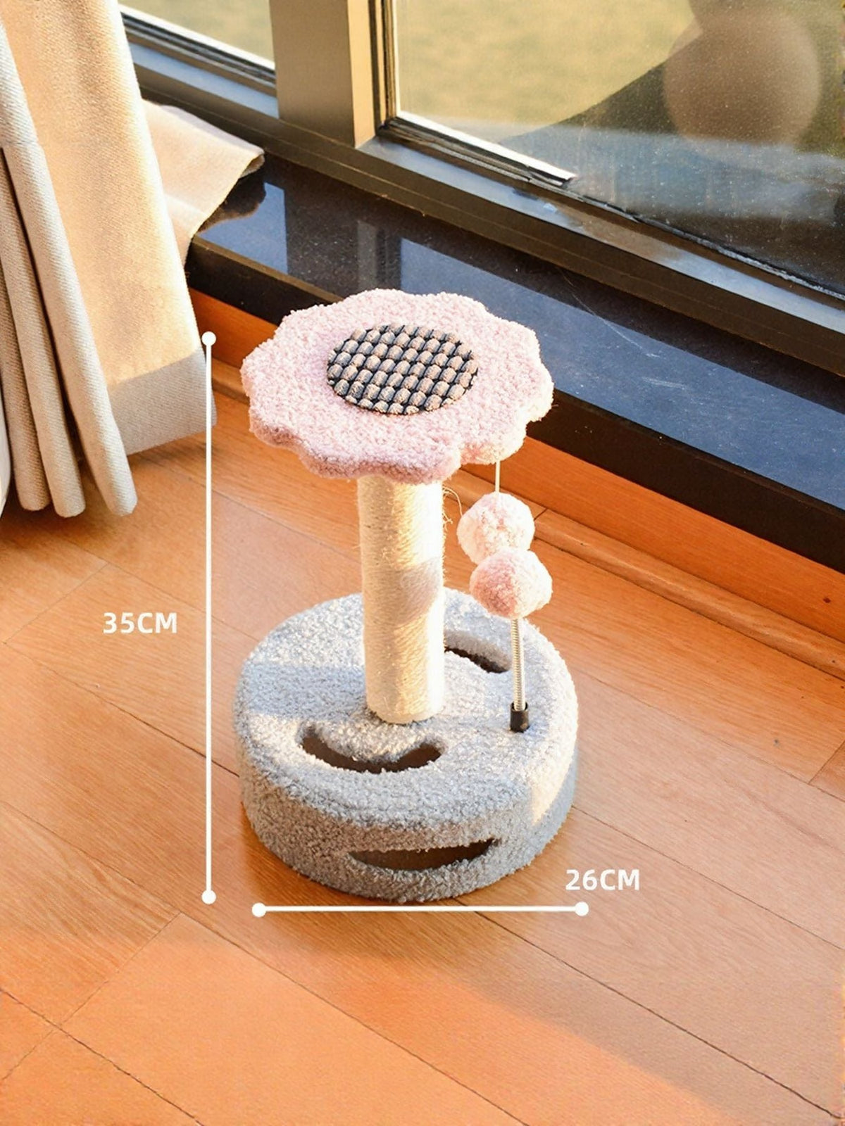 Cat scratching post with dangling balls, gray base with light pink flower top and pole.