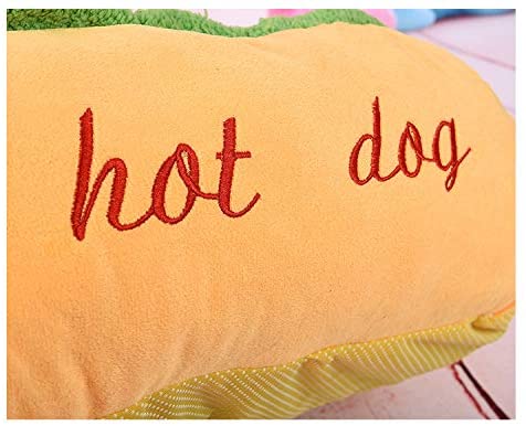 Hot dog-shaped pet bed close-up, red 'hot dog' embroidery on orange plush.