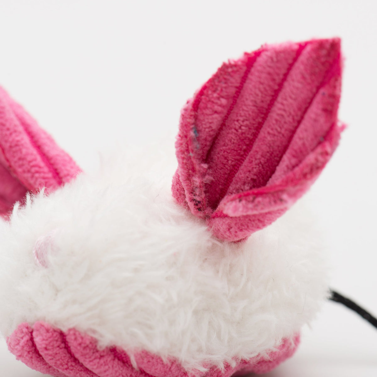 Close-up of pink and white plush dust bunny cat toy with ridged ears