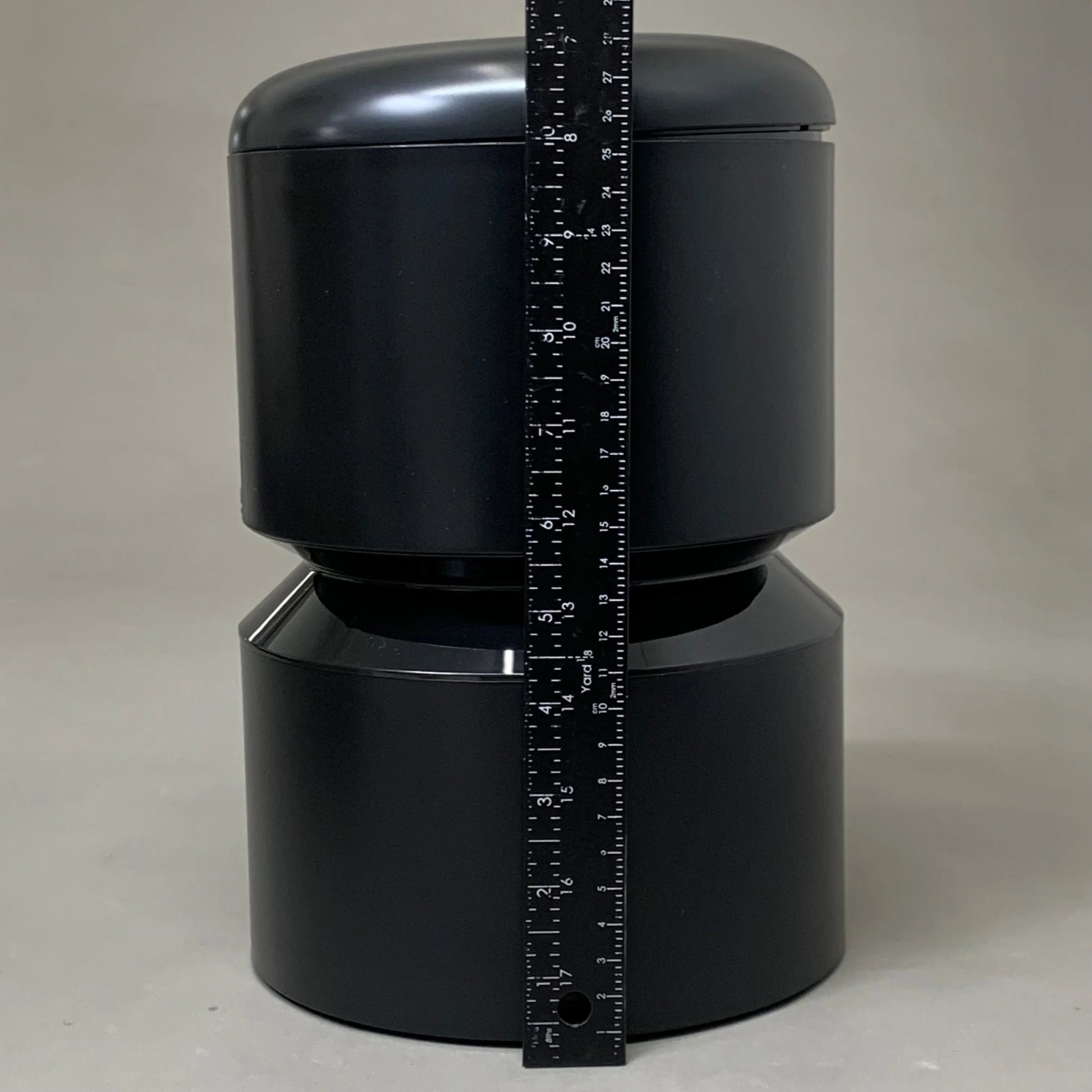 Black automatic cat feeder body with measuring tape vertically