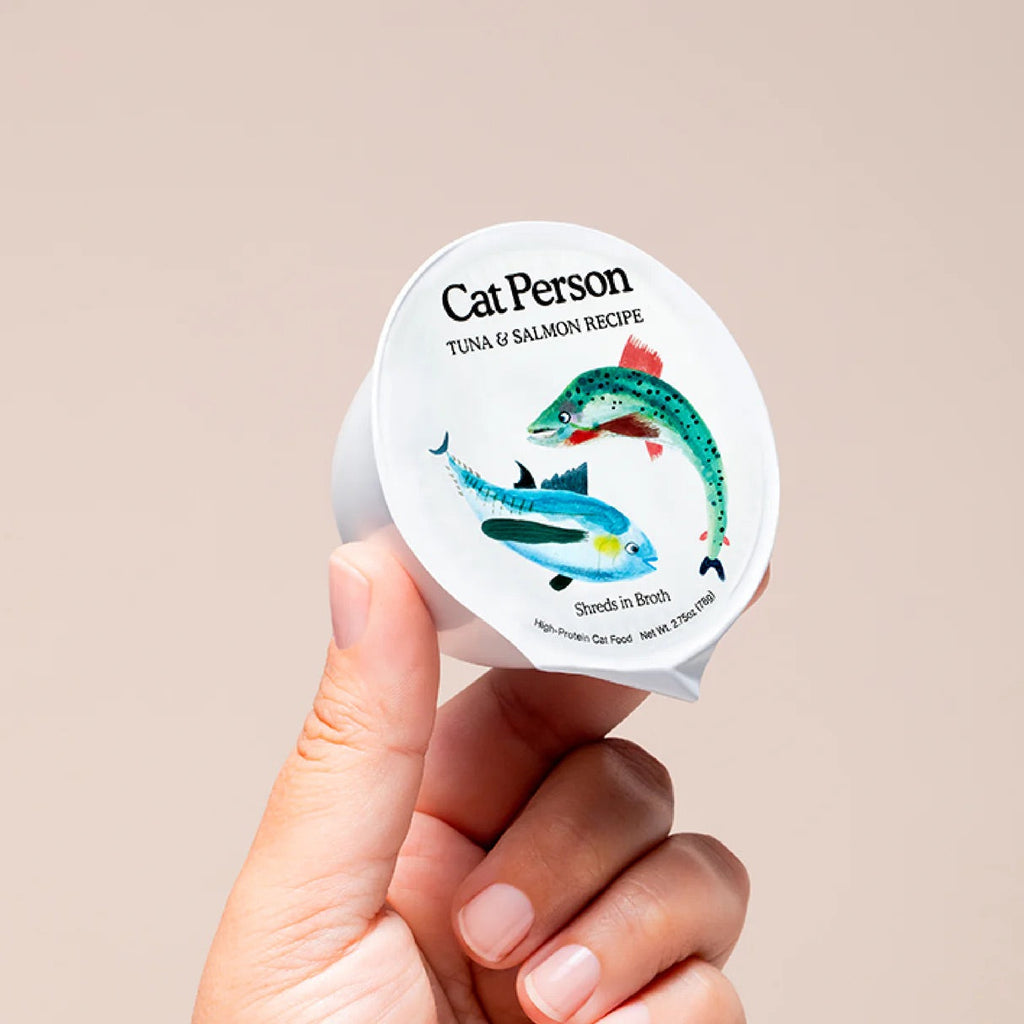Cat Person cat food cup held by hand, tuna and salmon shredded in broth label