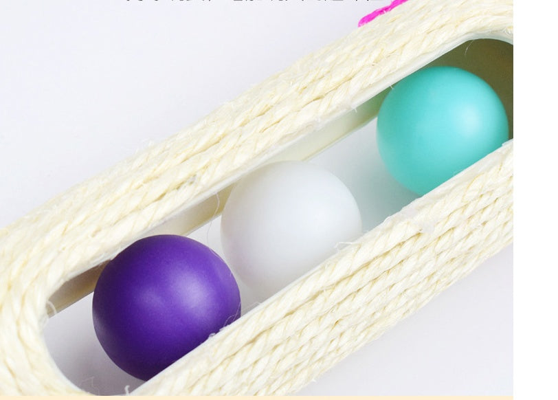 Close-up of teal and purple balls inside a beige rope tunnel on a sisal drum toy
