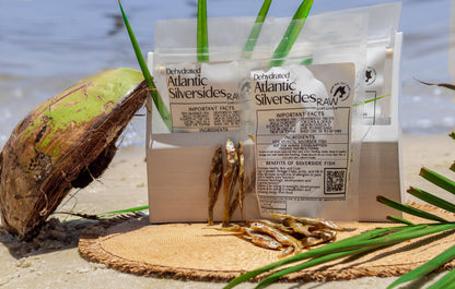 Dehydrated Atlantic silverside fish treat bags with dried fish on sandy surface