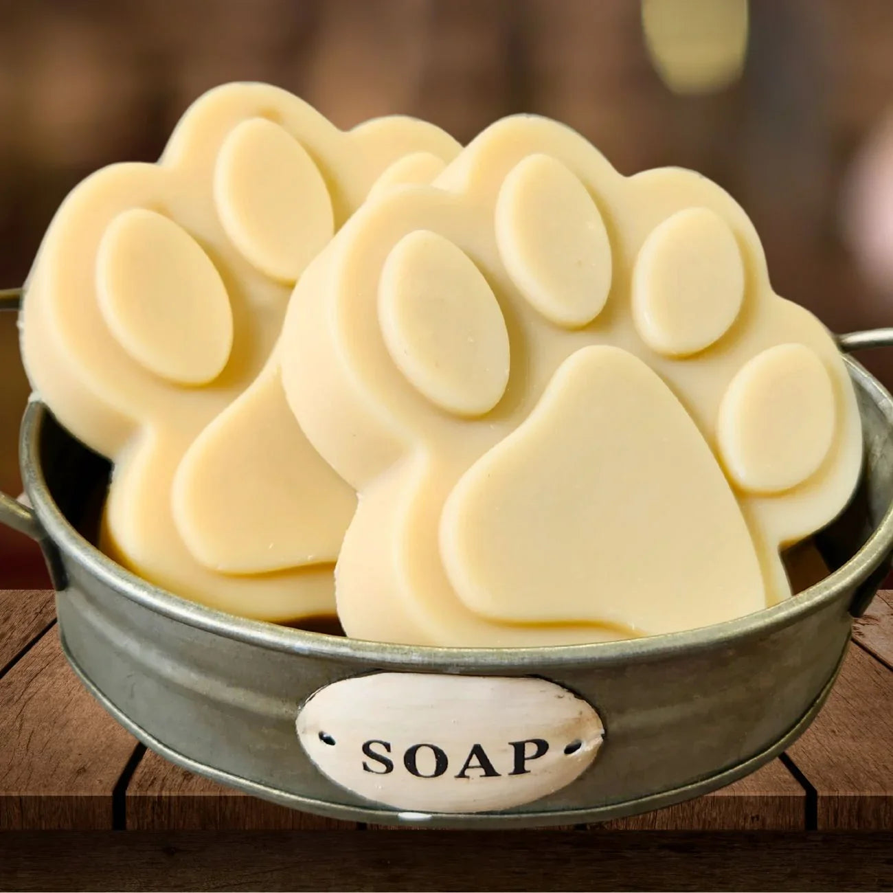 Paw-shaped goat milk soap bar slices in metal dish