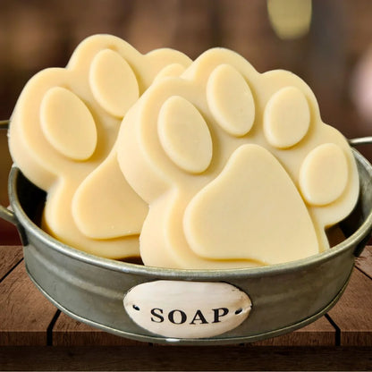 Paw-shaped goat milk soap bar slices in metal dish
