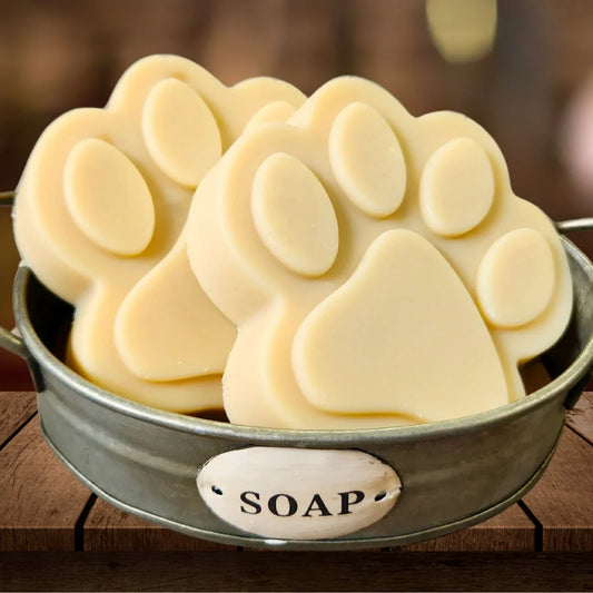 Paw-shaped goat milk soap bar slices in metal dish