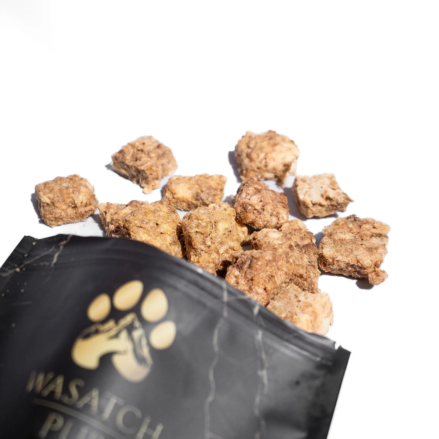 Freeze-dried chicken crisps dog treats, with black Wasatch Pup pouch and crunchy pieces