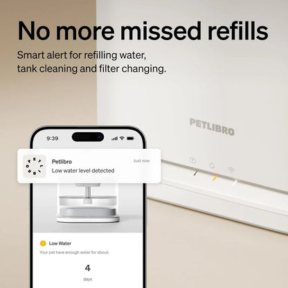 White pet water fountain with smart notification phone screen shown beside it.
