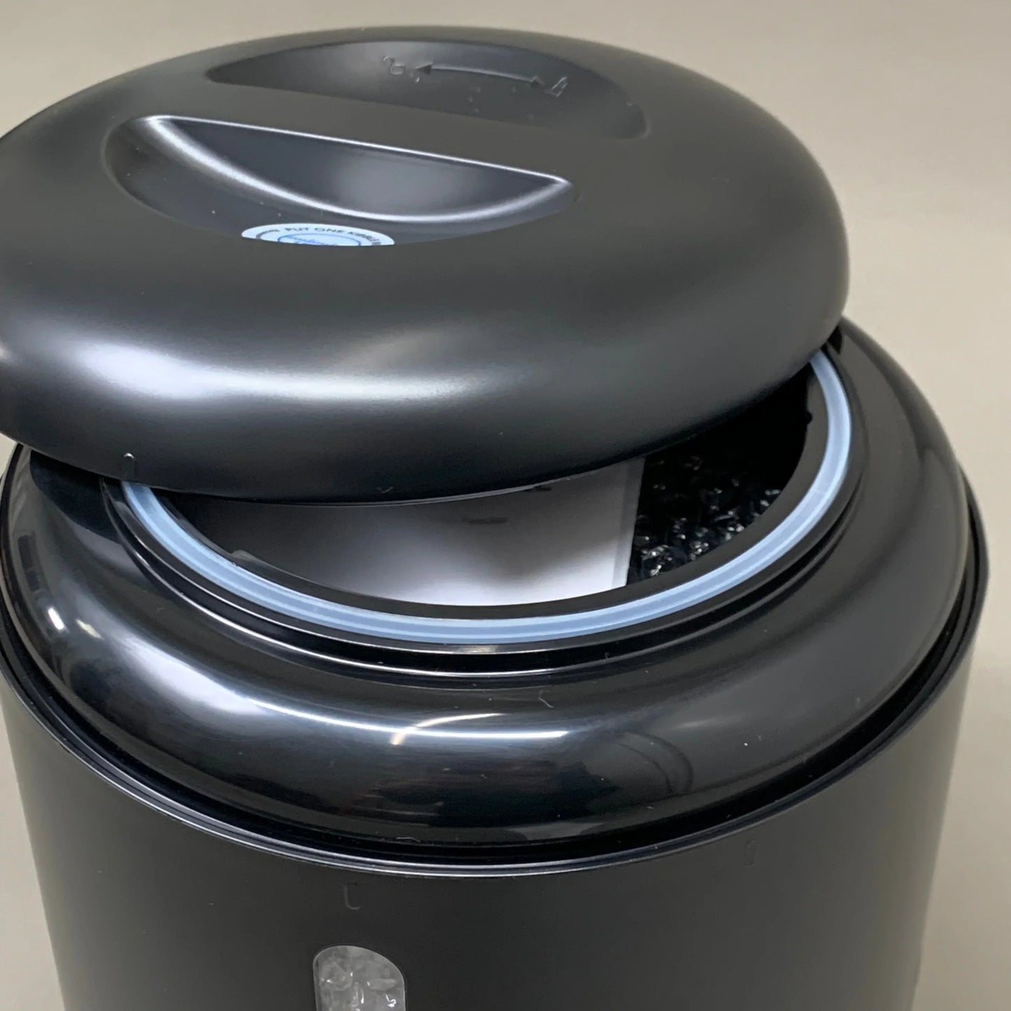 Black automatic cat feeder top open, showing inner bowl and loading chute