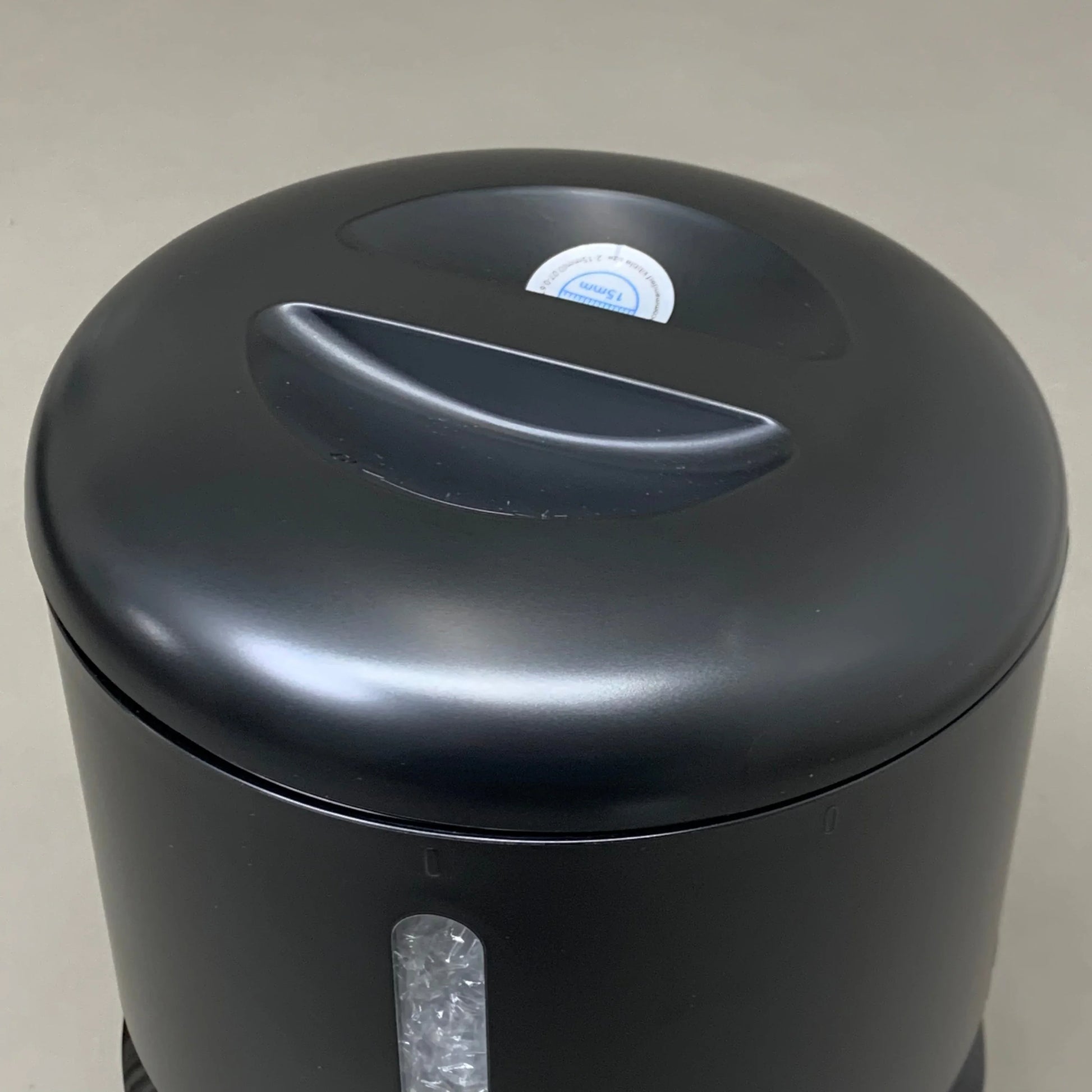 Black feeder lid with round sticker label on top panel