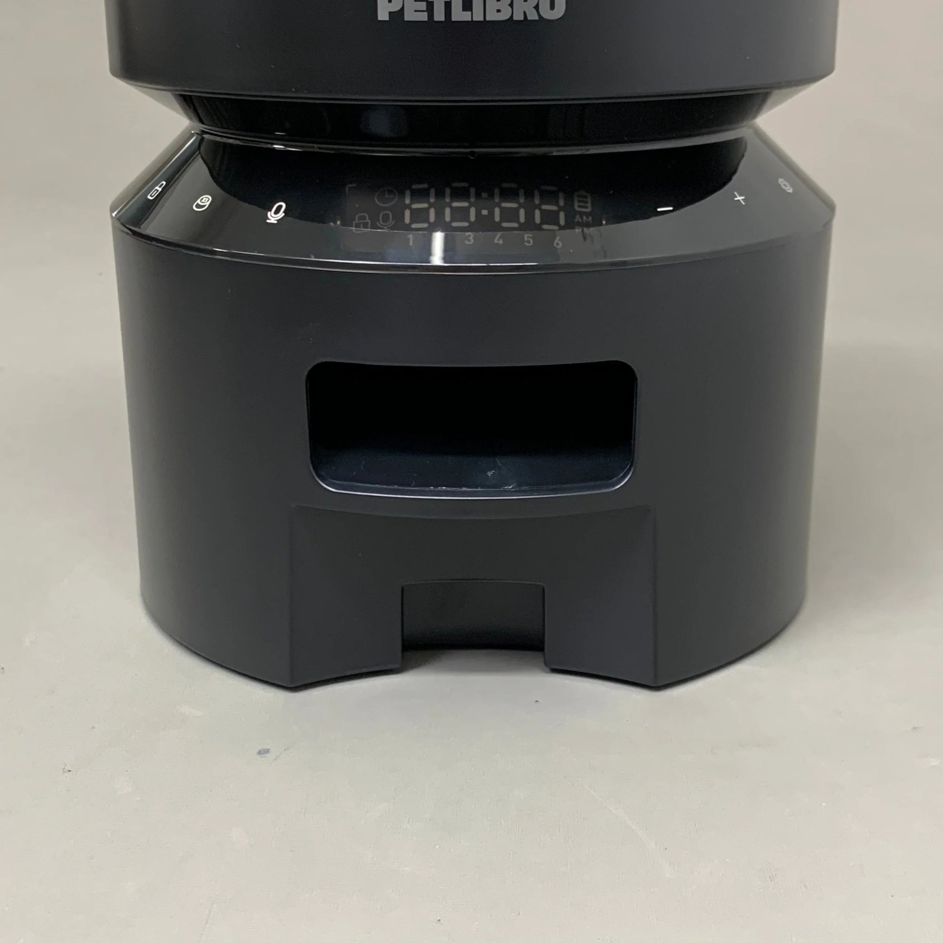 Black automatic feeder base with front access opening and numbered control strip