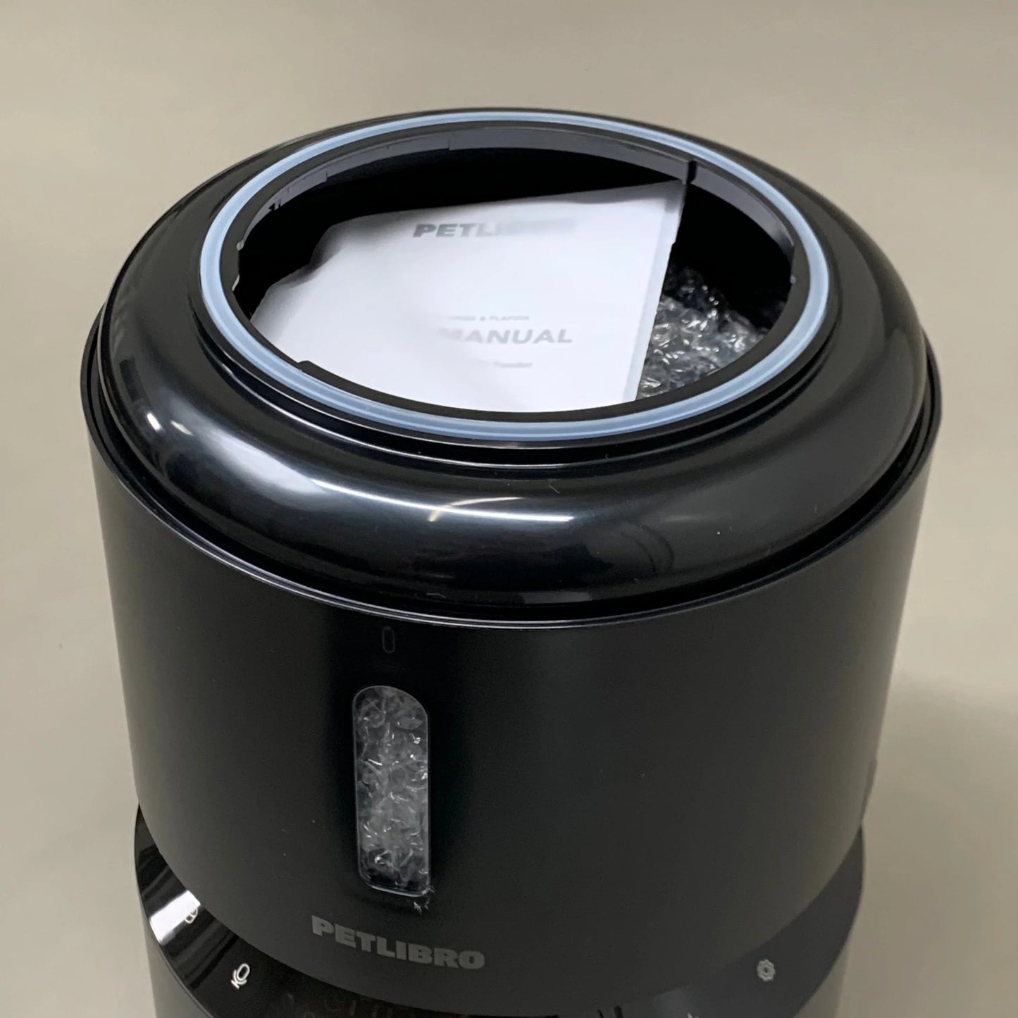 Black automatic cat feeder with top open, inner tray area visible