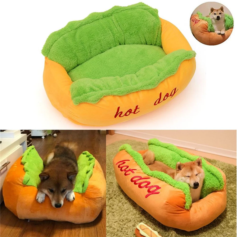 Hot dog shaped pet bed with green plush top and orange base; dog resting inside