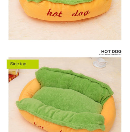 Hot dog-shaped pet bed side view, orange base with green nest pad and red embroidery.
