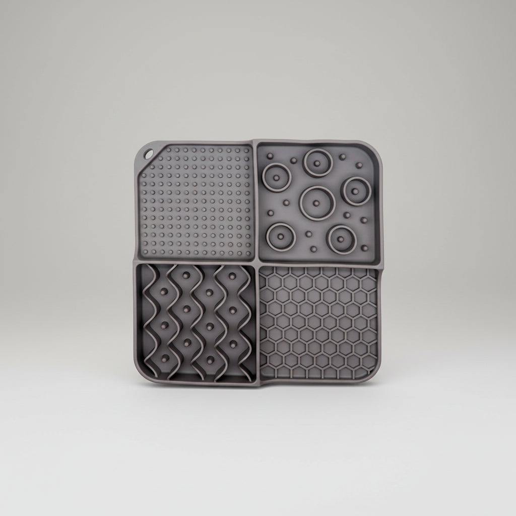 Gray silicone slow feeder lick mat with suction-dot panel, disk bumps, and honeycomb section
