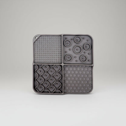Gray silicone slow feeder lick mat with suction-dot panel, disk bumps, and honeycomb section