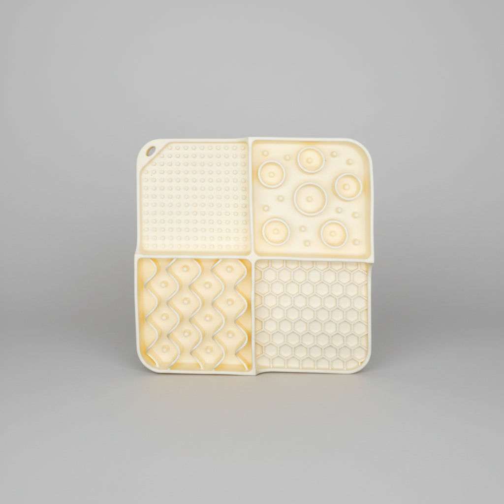 Cream silicone slow feeder lick mat with dotted, circle-bump, diamond, and honeycomb textures