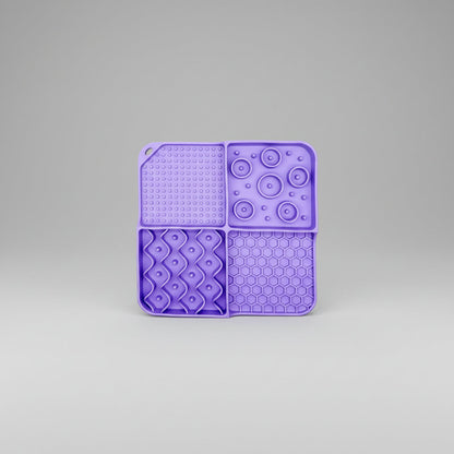 Purple silicone slow feeder lick mat with dotted, paw-bubble, diamond, and hexagon textures