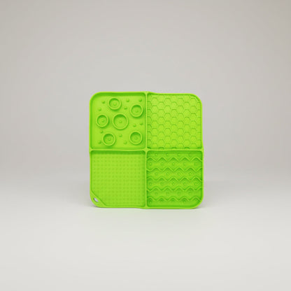 Green silicone slow feeder lick mat with raised paw, hex, and swirl textures