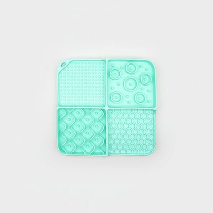 Mint silicone slow feeder lick mat in four sections with dot, swirl, and honeycomb textures