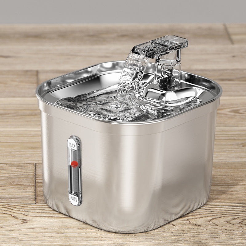 Stainless steel pet water fountain on a wooden surface with visible recirculating water
