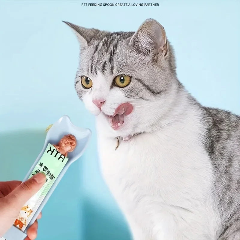 Blue cat lick treat spoon held near gray-and-white cat licking