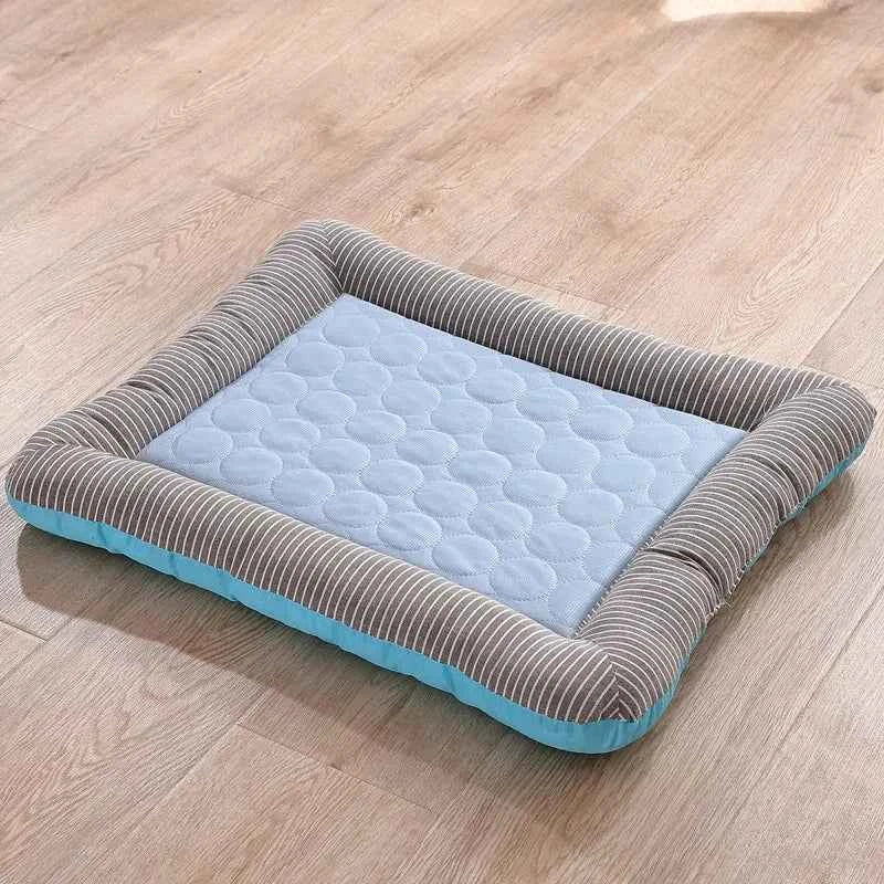 Blue cooling pet mat with light blue dotted surface and striped padded border.