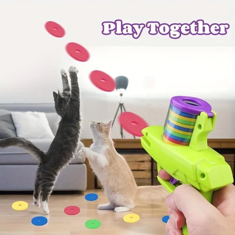 Green cat disc launcher toy held near cats with colorful flying soft discs