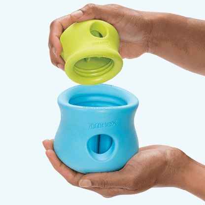 Green silicone dog treat toy bowl and blue silicone bowl being held