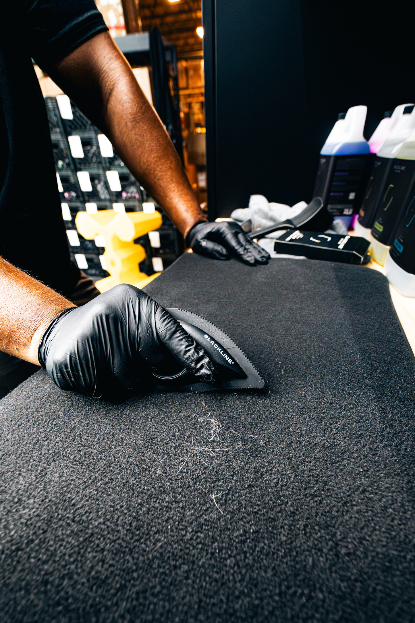 Pet grooming brush being used on grooming mat with black bristles