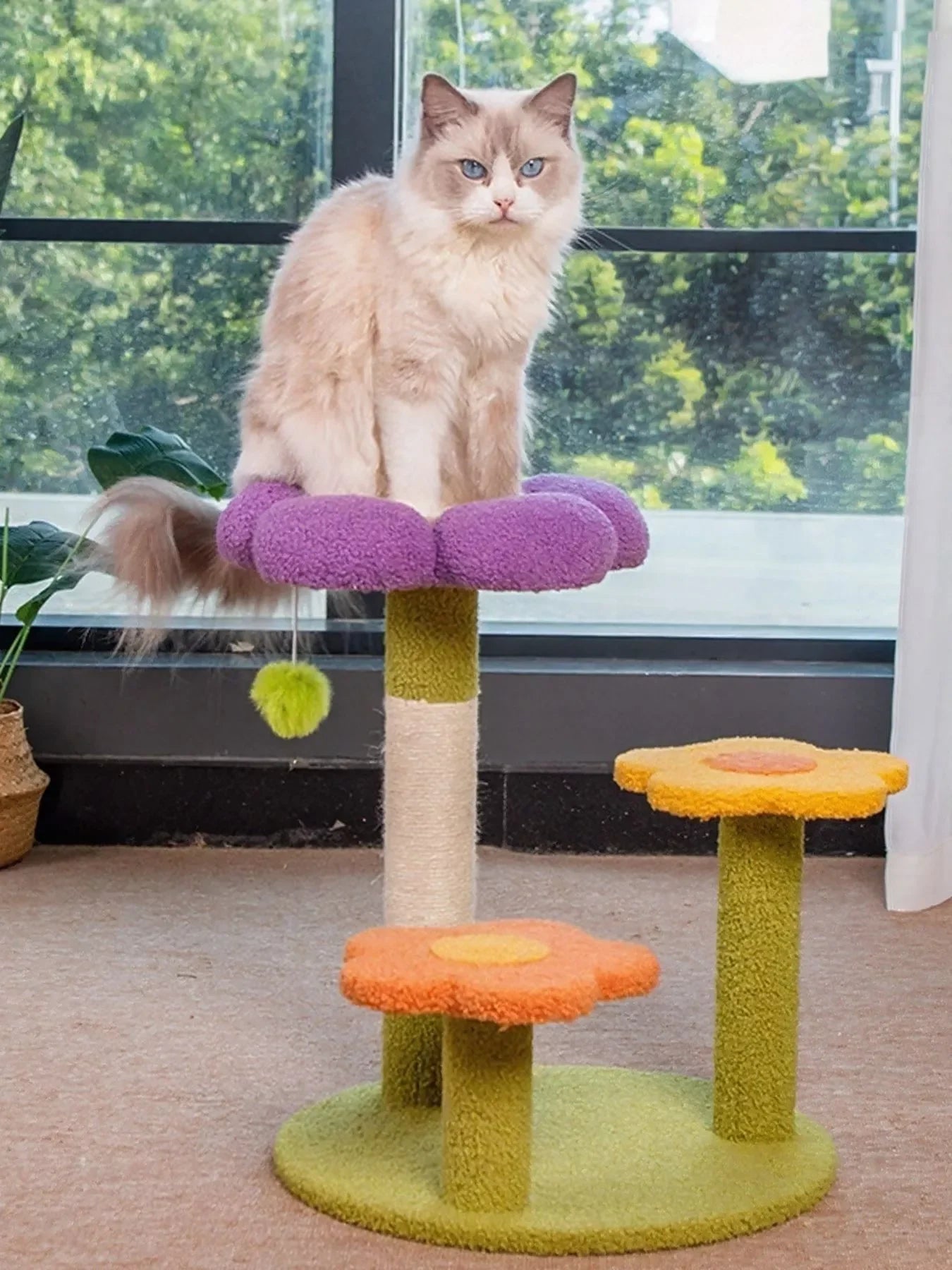 Fluffy cat on purple flower perch of plush cat tree with green and orange platforms