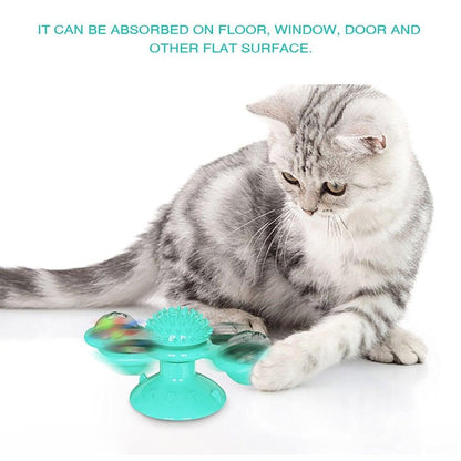 Cat windmill toy on floor with teal spiky pad and two rotating domed side cups