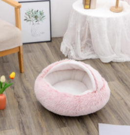 Oval pink plush pet bed with soft raised rim and hollow center
