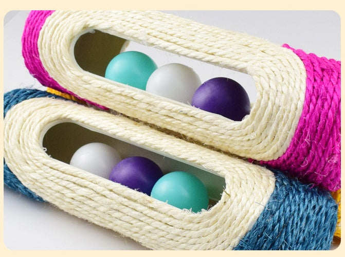 Close-up of pink and blue sisal drum toys with teal, purple, and white balls in tunnels