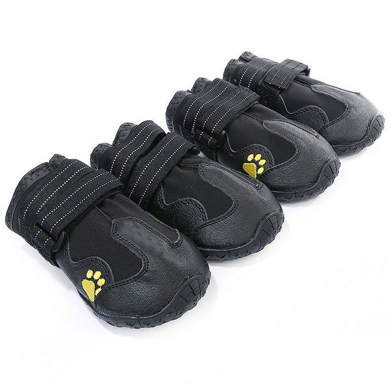 Black waterproof dog boots with paw-print logos, textured tread soles, hook straps