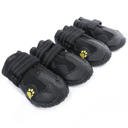 Black waterproof dog boots with paw-print logos, textured tread soles, hook straps
