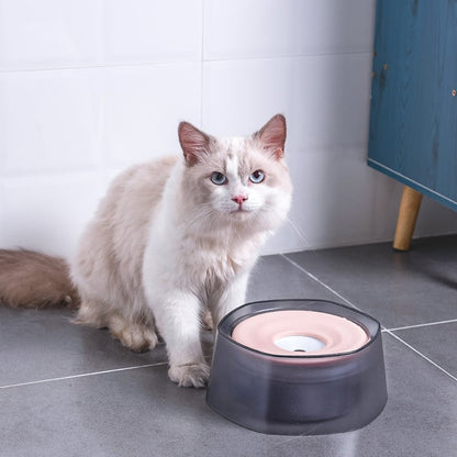 Splash-proof pet drinking bowl with pink water next to a white cat