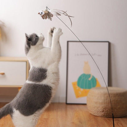 White and gray cat reaching for gray plush feather toy on teaser wand line